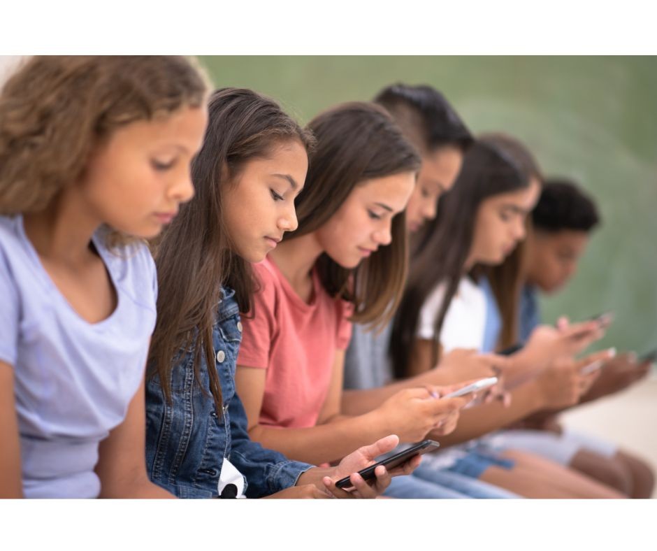 Imagen de adolescentes concentrados en sus teléfonos, evidenciando cómo la era digital domina las interacciones juveniles